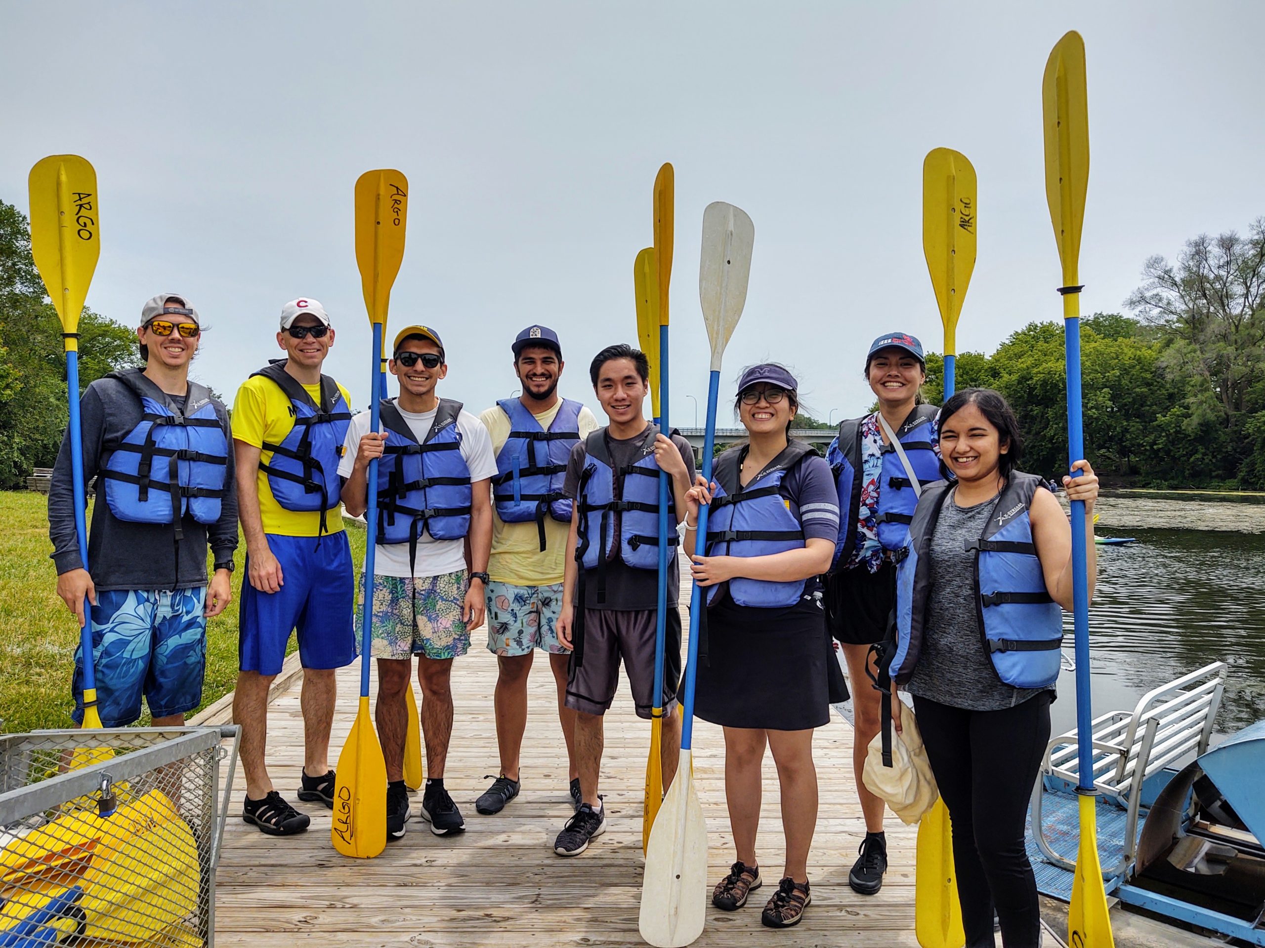 Group photo of people holding kayak paddles