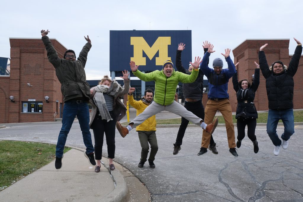 People jumping in air in front of the big house